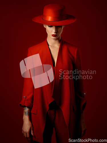 Image of Fashion, suit and hat on woman with beauty in studio with retro, style and edgy, confident or creative pose on red background mockup. Mystery character, model and girl with power or vintage aesthetic