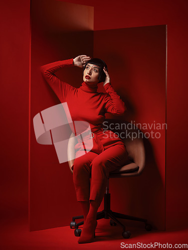 Image of Fashion, beauty and a young woman on red background in studio for elegant, chic or trendy style. Aesthetic, art and confident with an edgy or classy model person in unique clothes or suit at board