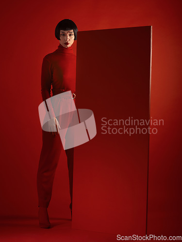 Image of Fashion, art and portrait of woman with red board, futuristic makeup and unique studio background. Future aesthetic, cyberpunk and creative beauty, body of model in dark luxury designer brand mockup.