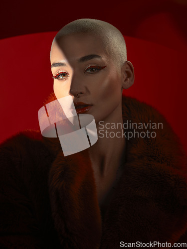 Image of Portrait, fashion and serious woman in red coat in studio isolated on a background. Face, makeup and bald female model with cosmetics, aesthetics or stylish, trendy or classy clothes from Switzerland