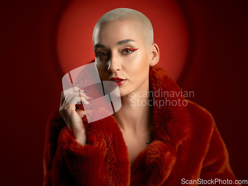 Image of Fashion, portrait and confident woman in a red coat in studio isolated on a background. Face, makeup and serious model with cosmetics, aesthetic and style, trendy and fur clothes from Switzerland.