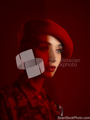 Image of Woman, fashion and face with red aesthetic, beauty and makeup with vintage hat isolated on studio background. Retro style, female model with serious expression and cosmetics, attractive and bold