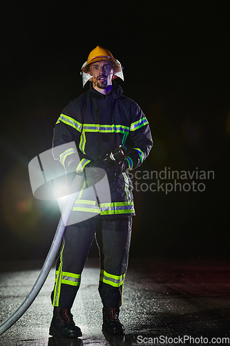 Image of Firefighters using a water hose to eliminate a fire hazard. Team of female and male firemen in dangerous rescue mission.