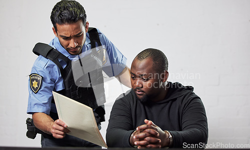 Image of Policeman, criminal and handcuffs with documents for interrogation, question or arrest in fraud, scam or crime. Law enforcement officer talking to prisoner or thief with paperwork in prison or jail