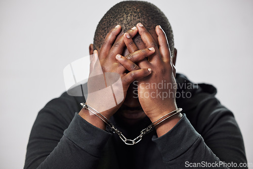 Image of Handcuffs, arrested criminal and black man with stress, worry and anxiety in police station for crime. Law, punishment and male person with chains for investigation, theft and fraud suspect in prison