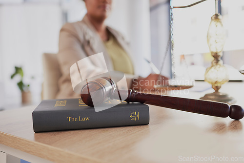 Image of Gavel, law firm and books on table of attorney in office for judge, justice and court trial. Closeup of advocate, lawyer and worker with hammer, research and legal notebook at desk for constitution