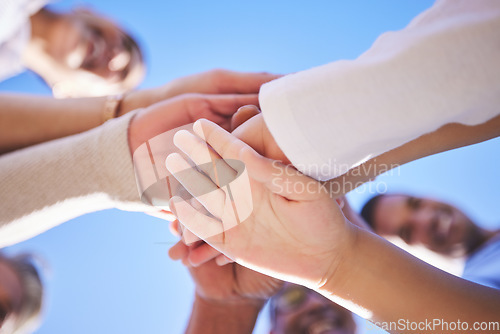 Image of People, hands together and teamwork below in support for trust, bonding or unity and collaboration outdoors. Low angle of family or friends piling hand for team building, community or goals outside