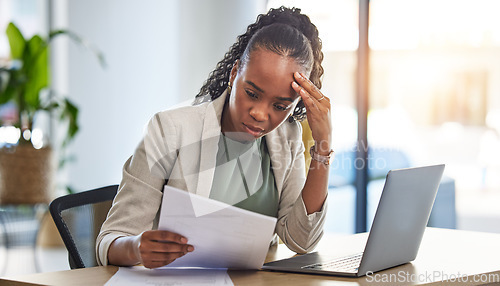 Image of Laptop, document and businesswoman with stress in the office while working on a project deadline. Overworked, computer and African female lawyer with burnout reading legal paperwork in the workplace.