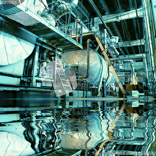 Image of Pipes, tubes, machinery and steam turbine at a power plant with 