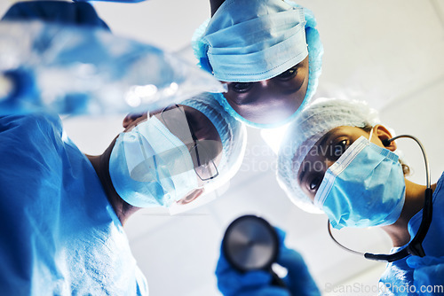 Image of Surgery, medical and a team of doctors in an operating room at the hospital for a medical procedure from patient pov. Face, mask and teamwork with a group of medicine professionals in an operation