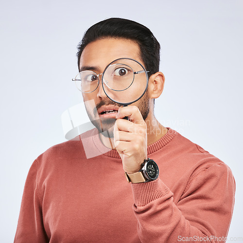 Image of Magnifying glass, man and focus in a studio with investigation for clues on crime. Isolated, white background and male person with inspection for scam, evidence and information on a job with shock