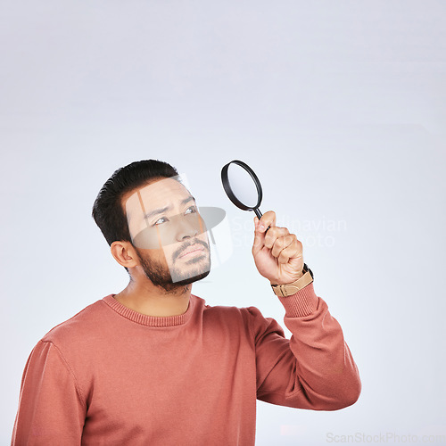 Image of Magnifying glass, man and serious in a studio with investigation for clues. Isolated, white background and male person with inspection for scam, crime evidence and information search with mockup