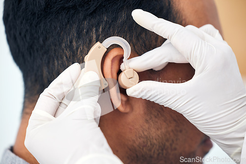 Image of Hearing aid, man and doctor hands with deaf patient consultation for ear and wellness at hospital. Help, employee and ear test of physician with tinnitus and consulting exam with healthcare expert