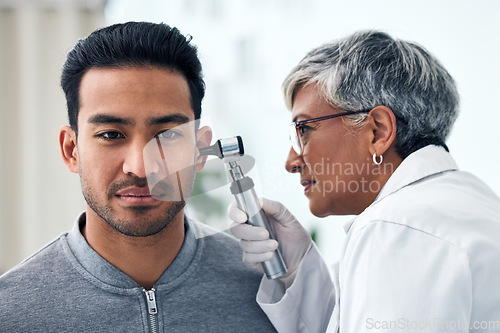 Image of Ear check, woman and ENT doctor with patient consultation for hearing and wellness at hospital. Senior, employee and otoscope test of physician with health insurance and consulting exam for tinnitus