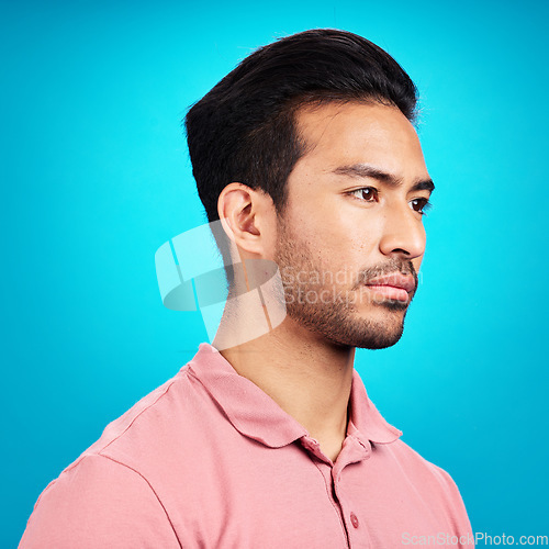 Image of Thinking, serious and profile of Asian man in studio isolated on a blue background. Idea, side face and male person contemplating, lost in thoughts or problem solving while looking for a solution.