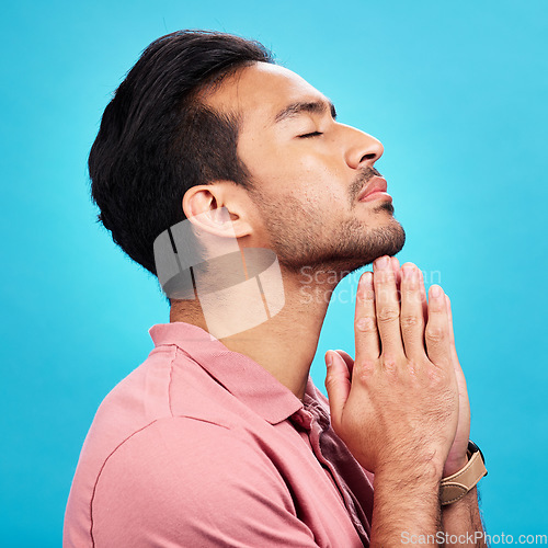 Image of Profile, religion and praying man in studio isolated on a blue background. Christian, spiritual and male person with prayer, gratitude and faith to worship God, Jesus and Holy Spirit with meditation.