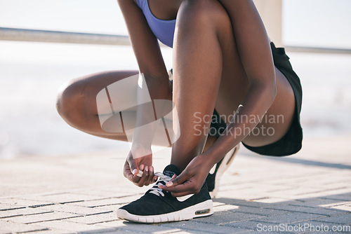 Image of Hands, city and runner tie shoes to start workout, training or exercise outdoor. Sports, fitness and athlete tying laces on sneakers to prepare for cardio, running and jog for body health or wellness