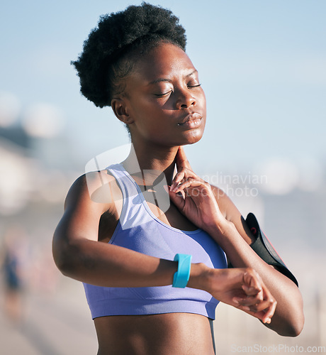 Image of Fitness, wellness and athlete checking her pulse with smartwatch for running outdoor in nature. Sports, workout and African woman monitoring her heart rate for cardio training for race or marathon.