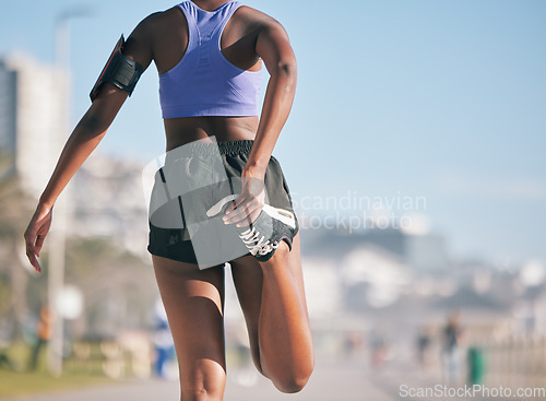 Image of Stretching legs, fitness and back of a woman in the city for running, exercise and training for a marathon. Morning, outdoor warm up and an athlete ready to start a workout, cardio or sports