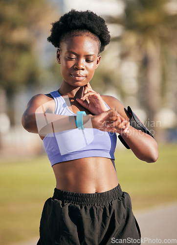 Image of Fitness, pulse and female athlete on a workout with smartwatch for running outdoor in nature. Sports, exercise and African woman monitoring her heart rate for cardio training for race or marathon.