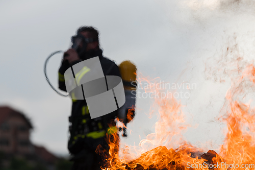 Image of Portrait of a heroic fireman in a protective suit. Firefighter in fire fighting operation.