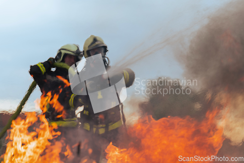 Image of Firefighters fight the fire flame to control fire not to spreading out. Firefighter industrial and public safety concept. Traffic or car accident rescue and help action.