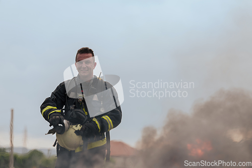 Image of Portrait of a heroic fireman in a protective suit. Firefighter in fire fighting operation.