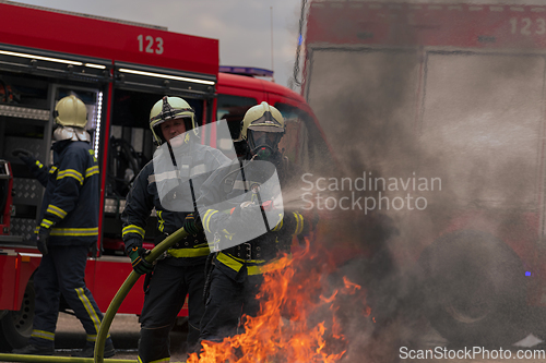 Image of Firefighters fight the fire flame to control fire not to spreading out. Firefighter industrial and public safety concept. Traffic or car accident rescue and help action.