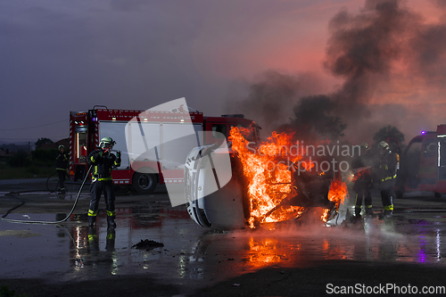 Image of Firefighters fight the fire flame to control fire not to spreading out. Firefighter industrial and public safety concept. Traffic or car accident rescue and help action.