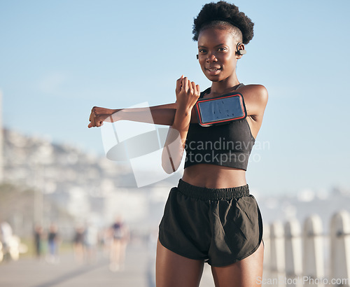 Image of Portrait, music and stretching with a sports black woman outdoor on a blurred background for cardio or endurance training. Exercise, health or phone with a young runner getting ready for a workout