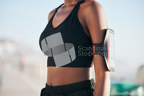 Image of Runner woman, phone and arm in closeup for wearable tech, fitness and tracking info for exercise goals. Girl, smartphone app and armband to monitor for workout, steps and progress for healthy body