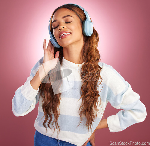 Image of Woman, headphones and music in studio, happy and listening to relax by gradient background. Young student girl, audio tech and listen with sound, streaming and service online with happiness for peace