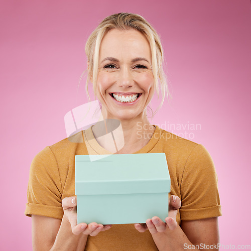 Image of Portrait, gift and old woman with smile, excited and cheerful with celebration against studio background. Face, mature female and senior lady with box, package and present with happiness and backdrop