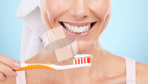 Image of Closeup of woman, smile and toothbrush isolated on a blue background for dental or orthodontics health. Beauty model or person mouth, brushing teeth with toothbrush product and toothpaste in studio