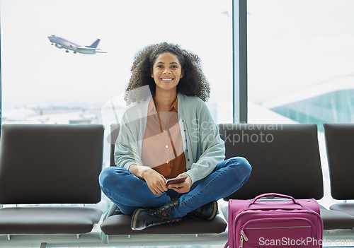 Image of Airport, black woman and portrait of a young person at flight terminal waiting for airplane travel. Passport document, smile and sitting solo female traveler feeling happy with freedom from adventure