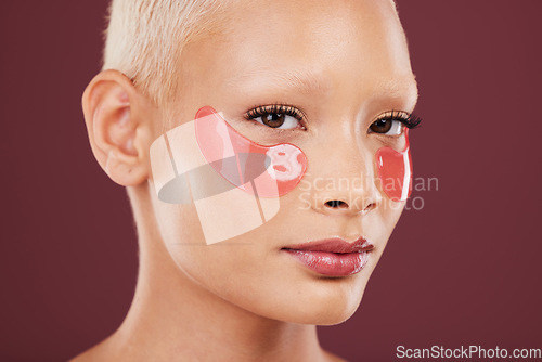 Image of Portrait, eye mask and beauty with a model black woman posing in studio on a red background for skincare. Face, skin and antiaging with an attractive young female posing to promote a cosmetic product