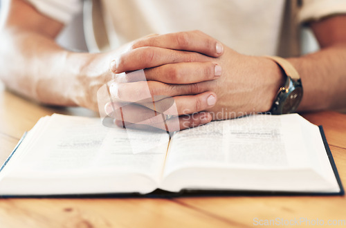 Image of Religion, reading and hands of a man with a bible for prayer, worship and hope. God, christian and spiritual person with belief in Jesus, looking for support and help from a religious book on a table