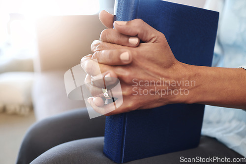 Image of Book, prayer and hands of old woman in living room for religion, bible and Christian faith. Spiritual, God and worship with senior lady praying with holy text at home for wellness, believe and goal
