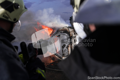 Image of Firefighters fight the fire flame to control fire not to spreading out. Firefighter industrial and public safety concept. Traffic or car accident rescue and help action.