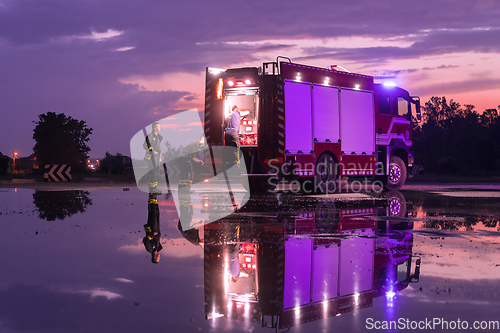 Image of Fire truck emergency vehicle. Firefighting apparatus and water to save lives, suppress wildfire, extinguish building fires and assist vehicle collisions or traffic car crash accidents.