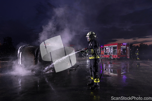 Image of Firefighters fight the fire flame to control fire not to spreading out. Firefighter industrial and public safety concept. Traffic or car accident rescue and help action.