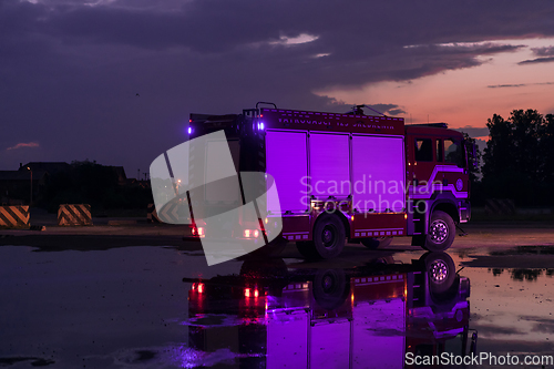 Image of Fire truck emergency vehicle. Firefighting apparatus and water to save lives, suppress wildfire, extinguish building fires and assist vehicle collisions or traffic car crash accidents.