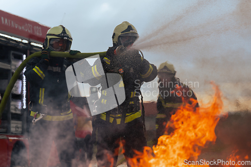 Image of Firefighters fight the fire flame to control fire not to spreading out. Firefighter industrial and public safety concept. Traffic or car accident rescue and help action.