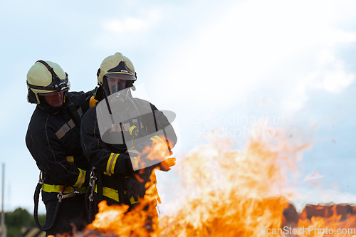 Image of Firefighters fight the fire flame to control fire not to spreading out. Firefighter industrial and public safety concept. Traffic or car accident rescue and help action.