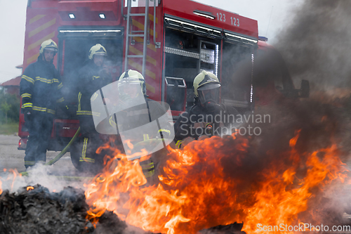 Image of Firefighters fight the fire flame to control fire not to spreading out. Firefighter industrial and public safety concept. Traffic or car accident rescue and help action.