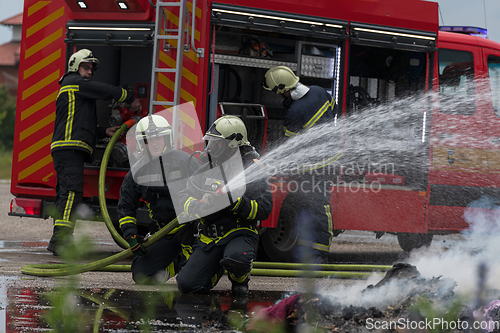 Image of Firefighters fight the fire flame to control fire not to spreading out. Firefighter industrial and public safety concept. Traffic or car accident rescue and help action.