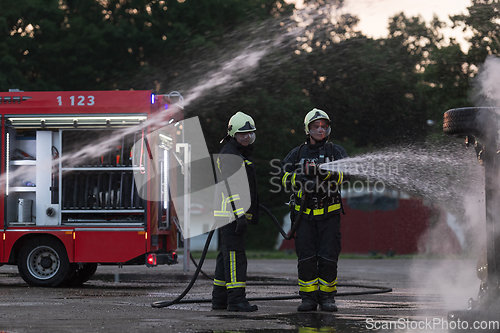 Image of Firefighters fight the fire flame to control fire not to spreading out. Firefighter industrial and public safety concept. Traffic or car accident rescue and help action.