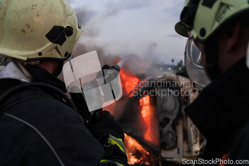 Image of Firefighters fight the fire flame to control fire not to spreading out. Firefighter industrial and public safety concept. Traffic or car accident rescue and help action.