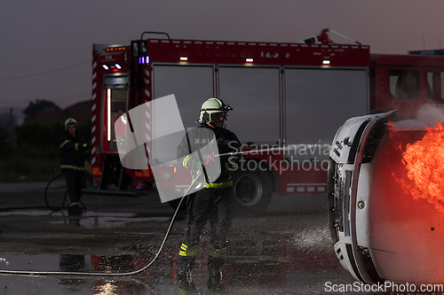 Image of Firefighters fight the fire flame to control fire not to spreading out. Firefighter industrial and public safety concept. Traffic or car accident rescue and help action.