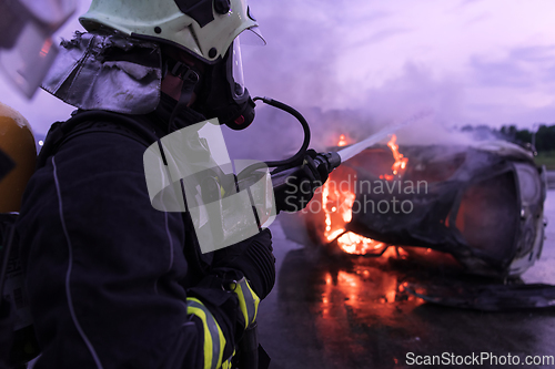 Image of Firefighters fight the fire flame to control fire not to spreading out. Firefighter industrial and public safety concept. Traffic or car accident rescue and help action.